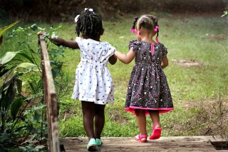 Picture of two little girls holding hands and walking.