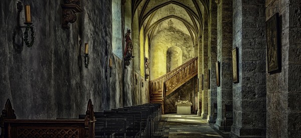 photo of monastery with shining light at end of corridor