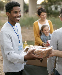 Image by Freepik: Man handing out bread in community