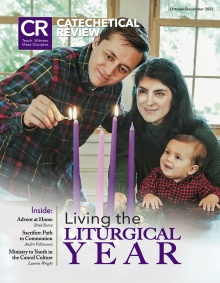 Cover of October 2022 issue with young family lighting the Advent wreath